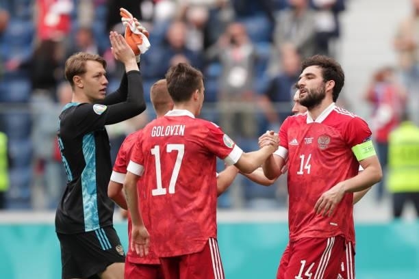 Georgi Dzhikiya of Russia shakes hands with team mate Aleksandr Golovin following victory in the UEFA Euro 2020 Championship Group B match between...