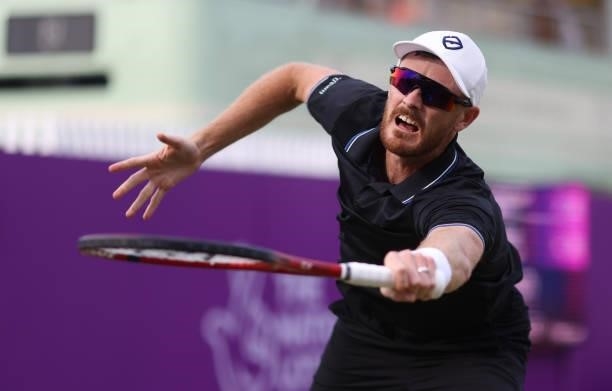 Jamie Murray of Great Britain, playing partner of Bruno Soares of Brazil stretches to play a backhand during there Round of 16 match against Aslan...