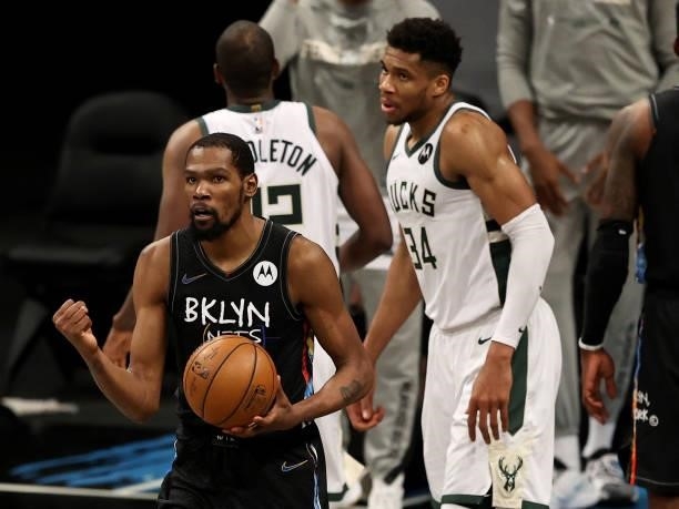 Kevin Durant of the Brooklyn Nets celebrates after he drew the foul as Giannis Antetokounmpo of the Milwaukee Bucks reacts in the fourth quarter...