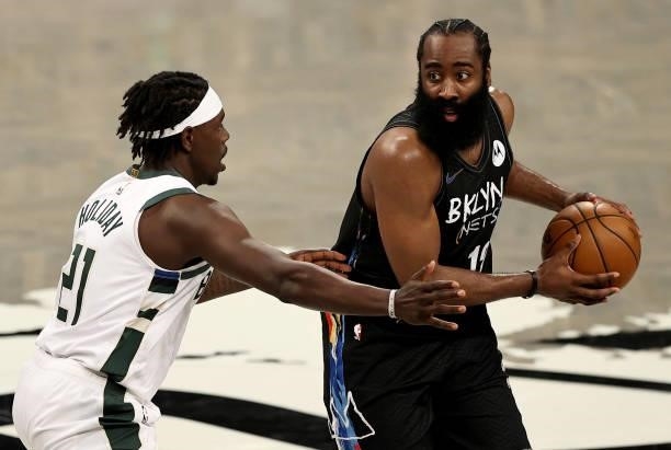 James Harden of the Brooklyn Nets looks to pass as Jrue Holiday of the Milwaukee Bucks defends in the second half during game 5 of the Eastern...