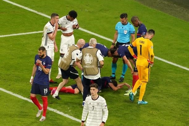 Benjamin Pavard of France receiving medical treatment during the UEFA Euro 2020 match between France and Germany at Allianz Arena on June 15, 2021 in...
