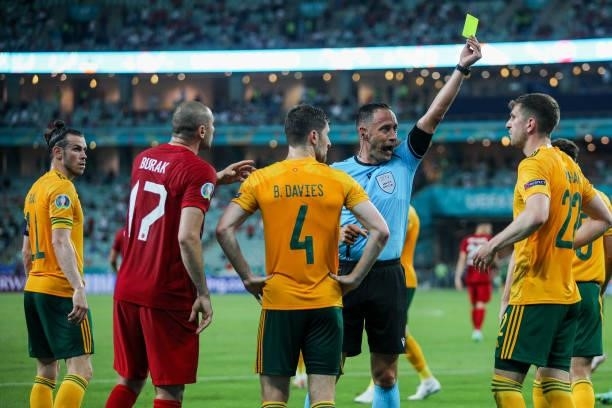 Portuguese referee Artur Dias presents a yellow card to Chris Mepham of Wales during the UEFA Euro 2020 Championship Group A match between Turkey and...