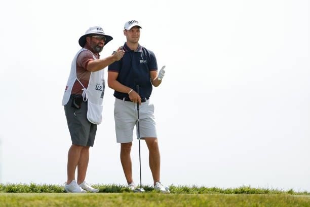 Martin Kaymer of Germany talks with caddie Craig Connelly before hitting his shot from the 17th tee during a practice round prior to the start of the...