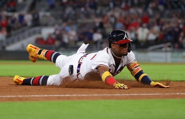 Ronald Acuna Jr. #13 of the Atlanta Braves slides into third base after attempting to advance on a RBI double in the ninth inning against the Boston...