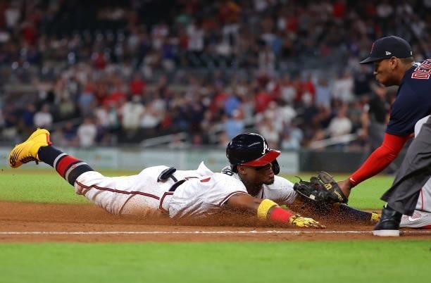 Ronald Acuna Jr. #13 of the Atlanta Braves is tagged out by Rafael Devers of the Boston Red Sox as he slides into third base after attempting to...