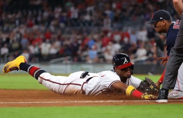 Ronald Acuna Jr. #13 of the Atlanta Braves is tagged out by Rafael Devers of the Boston Red Sox as he slides into third base after attempting to...