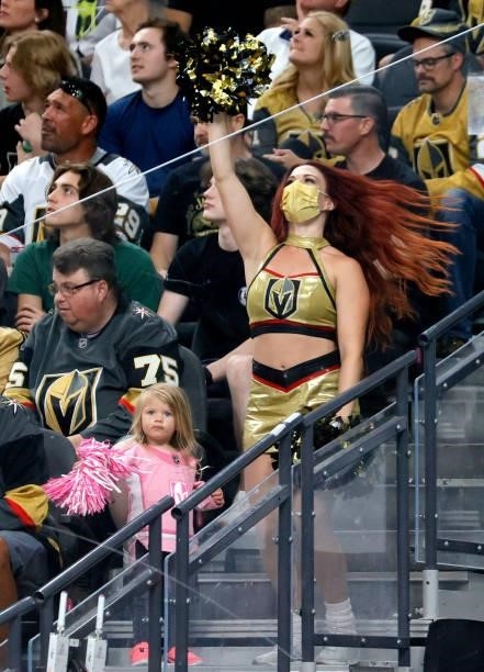 Member of the Vegas Golden Knights Vegas Vivas! cheerleaders cheers with a fan in the third period in Game Two of the Stanley Cup Semifinals during...