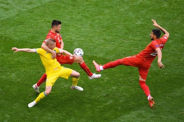 Oleksandr Zinchenko of Ukraine is challenged by Visar Musliu and Daniel Avramovski of North Macedonia during the UEFA Euro 2020 Championship Group C...