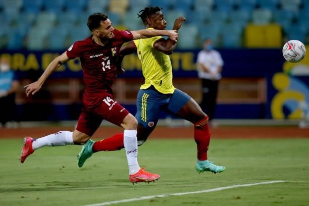 Duvan Zapata of Colombia fights for the ball with Luis Mago of Venezuela during a Group B match between Colombia and Venezuela as part of Copa...