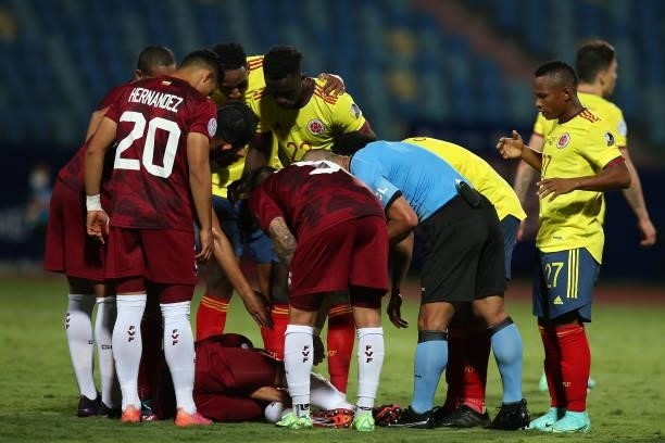 Referee Eber Aquino, Ronald Hernandez of Venezuela and Davinson Sanchez of Colombia check on an injured player of Venezuela during a Group B match...