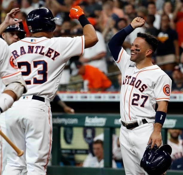Jose Altuve of the Houston Astros high fives Michael Brantley after Brantley's three-run home run in the first inning against the Chicago White Sox...