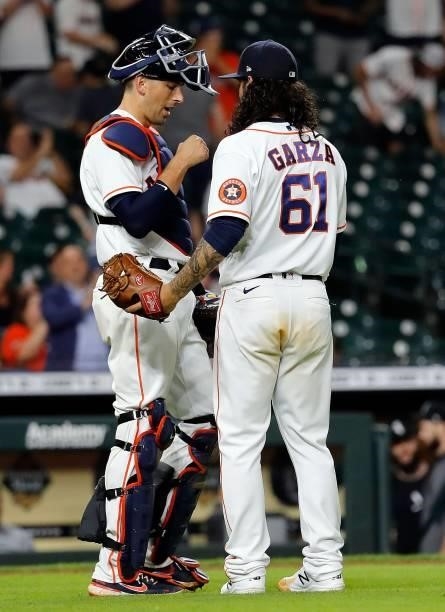 Jason Castro of the Houston Astros bumps fists with Ralph Garza Jr. #61 following a 10-2 win over the Chicago White Sox at Minute Maid Park on June...