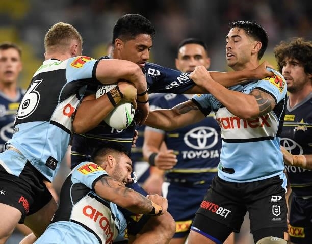 Murray Taulagi of the Cowboys is wrapped up by the sharks defence during the round 15 NRL match between the North Queensland Cowboys and the Cronulla...