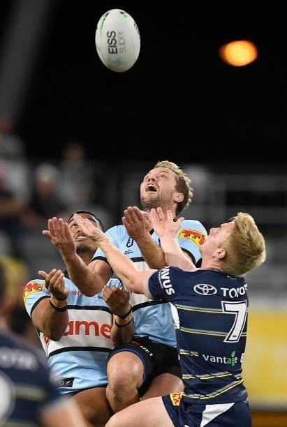 Matt Moylan of the Sharks contests the ball with Tom Dearden of the Cowboys during the round 15 NRL match between the North Queensland Cowboys and...