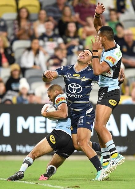 William Kennedy of the Sharks grabs the ball in front of Valentine Holmes of the Cowboys during the round 15 NRL match between the North Queensland...