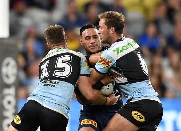 Valentine Holmes of the Cowboys is tackled by Matt Moylan and Teig Wilton of the Sharks during the round 15 NRL match between the North Queensland...