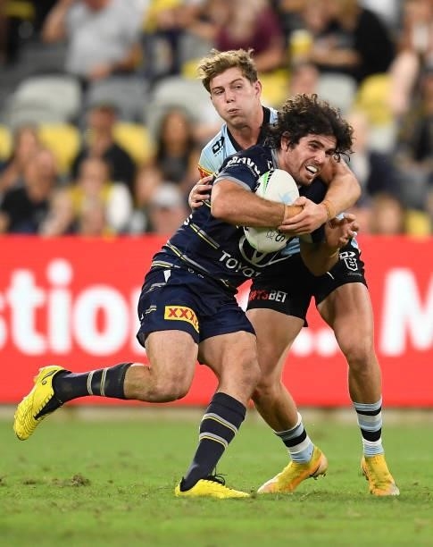Jake Granville of the Cowboys is tackled by Blayke Brailey of the Sharks during the round 15 NRL match between the North Queensland Cowboys and the...