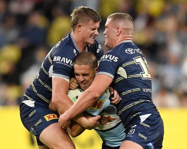 William Kennedy of the Sharks is tackled by Mitch Dunn and Tom Gilbert of the Cowboys during the round 15 NRL match between the North Queensland...