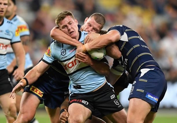 Teig Wilton of the Sharks is tackled during the round 15 NRL match between the North Queensland Cowboys and the Cronulla Sharks at QCB Stadium, on...