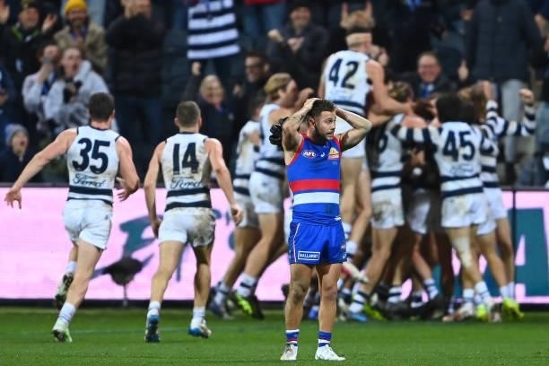Gary Rohan of the Cats is congratulated by team mates after kicking a goal to win the match as Caleb Daniel of the Bulldogs looks dejected during the...