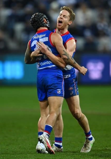 Caleb Daniel of the Bulldogs is congratulated by Lachie Hunter after kicking a goal during the round 13 AFL match between the Geelong Cats and the...