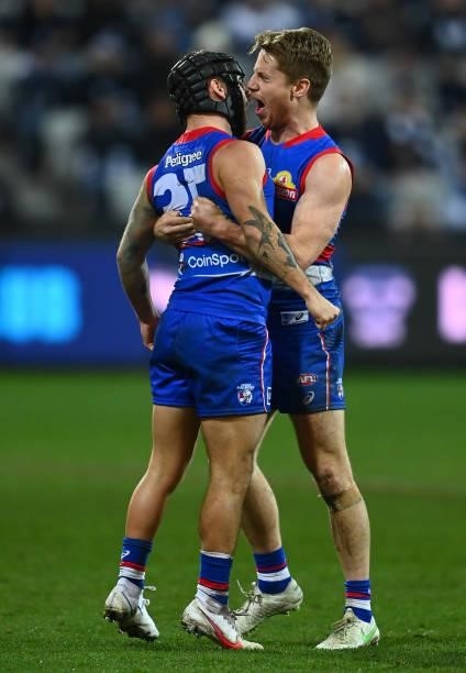 Caleb Daniel of the Bulldogs is congratulated by Lachie Hunter after kicking a goal during the round 13 AFL match between the Geelong Cats and the...