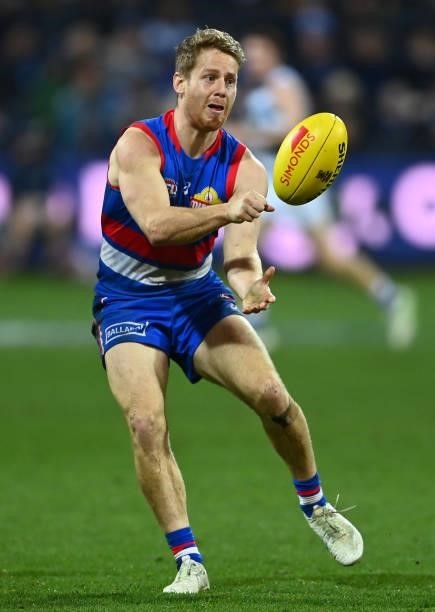 Lachie Hunter of the Bulldogs handballs during the round 13 AFL match between the Geelong Cats and the Western Bulldogs at GMHBA Stadium on June 18,...