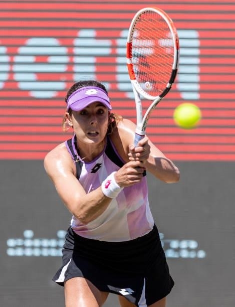 Alize Cornet of France hits a backhand against Garbine Muguruza of Spain in the women's singles quarter final match during day 7 of the bett1open at...