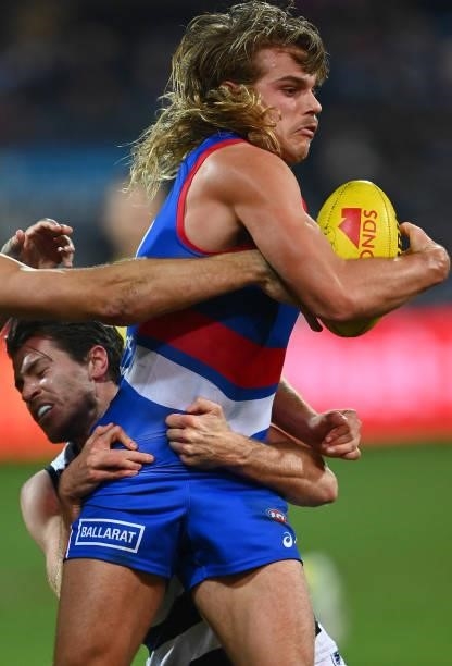 Bailey Smith of the Bulldogs is tackled by Isaac Smith of the Cats during the round 13 AFL match between the Geelong Cats and the Western Bulldogs at...