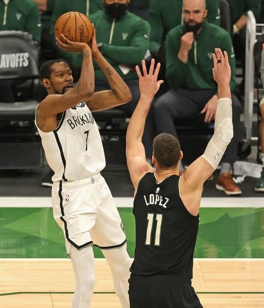 Kevin Durant of the Brooklyn Nets shoots over Brook Lopez of the Milwaukee Bucks at Fiserv Forum on June 17, 2021 in Milwaukee, Wisconsin. The Bucks...