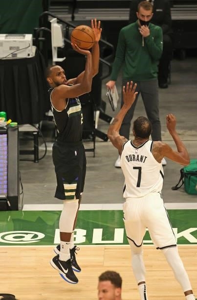Khris Middleton of the Milwaukee Bucks shoots over Kevin Durant of the Brooklyn Nets at Fiserv Forum on June 17, 2021 in Milwaukee, Wisconsin. The...
