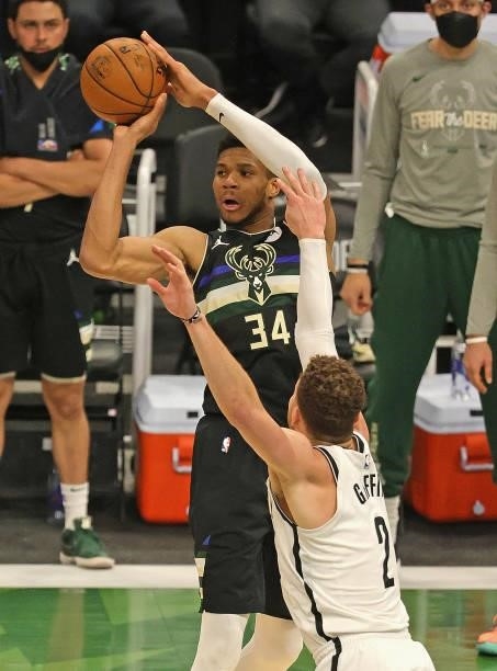 Giannis Antetokounmpo of the Milwaukee Bucks passes over Blake Griffin of the Brooklyn Nets at Fiserv Forum on June 17, 2021 in Milwaukee, Wisconsin....