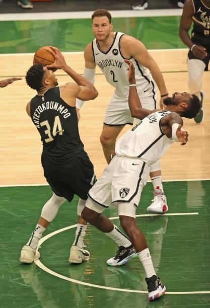 Giannis Antetokounmpo of the Milwaukee Bucks drives between Jeff Green and Blake Griffin of the Brooklyn Nets at Fiserv Forum on June 17, 2021 in...