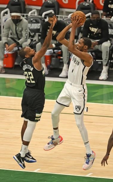 Kevin Durant of the Brooklyn Nets shoots over Khris Middleton of the Milwaukee Bucks at Fiserv Forum on June 17, 2021 in Milwaukee, Wisconsin. The...