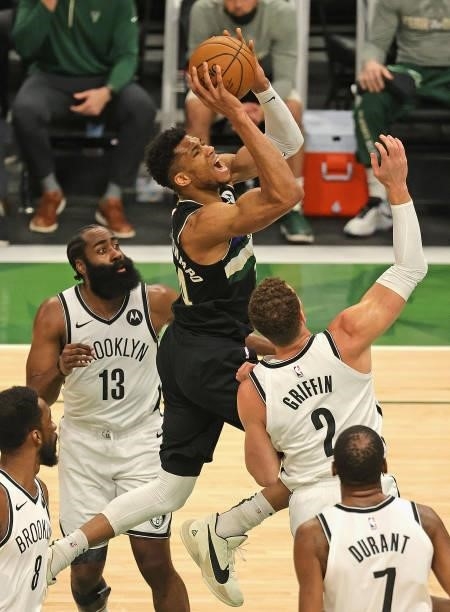 Giannis Antetokounmpo of the Milwaukee Bucks shoots between James Harden and Blake Griffin of the Brooklyn Nets at Fiserv Forum on June 17, 2021 in...