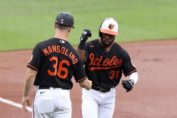Cedric Mullins of the Baltimore Orioles celebrates with third base coach Tony Mansolino after hitting a solo home run in the first inning against the...