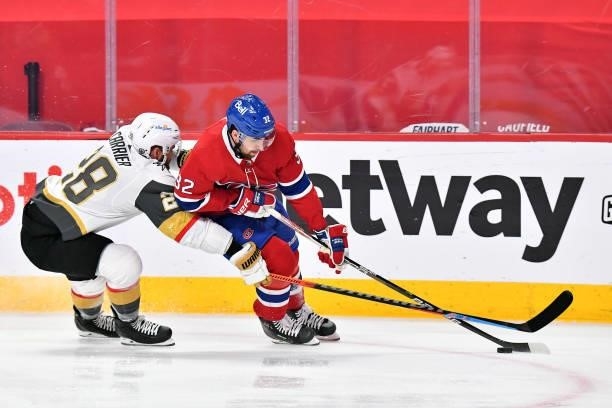 Erik Gustafsson of the Montreal Canadiens is defended by William Carrier of the Vegas Golden Knights during the first period in Game Three of the...