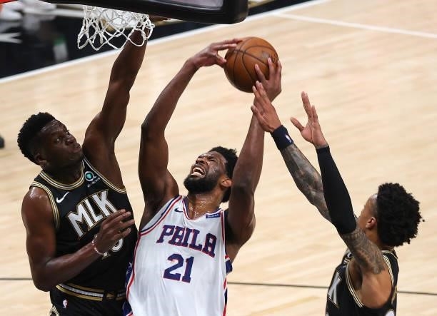 Joel Embiid of the Philadelphia 76ers drives against Clint Capela and John Collins of the Atlanta Hawks during the first half of game 6 of the...