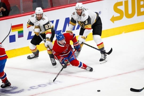 Cole Caufield of the Montreal Canadiens gets tripped up against Shea Theodore and Brayden McNabb of the Vegas Golden Knights during the first period...