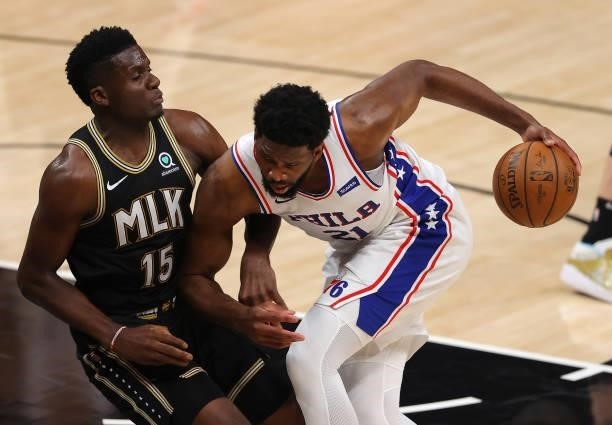 Clint Capela of the Atlanta Hawks draws an offensive foul as Joel Embiid of the Philadelphia 76ers drives into him during the first half of game 6 of...