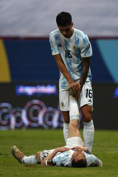 Joaquín Correa of Argentina helps stretch teammate Lionel Messi during a group A match between Argentina and Chile as part of Conmebol Copa America...