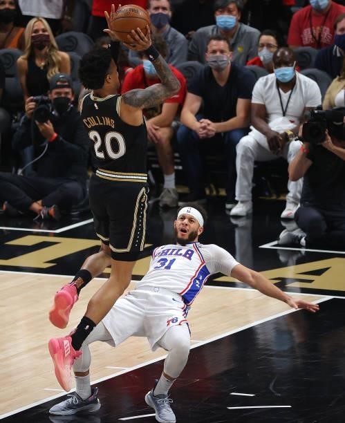 Seth Curry of the Philadelphia 76ers draws an offensive foul from John Collins of the Atlanta Hawks during the first half of game 6 of the Eastern...