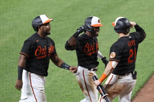 Cedric Mullins of the Baltimore Orioles celebrates with Maikel Franco and Austin Hays after hitting a three RBI home run against the Toronto Blue...