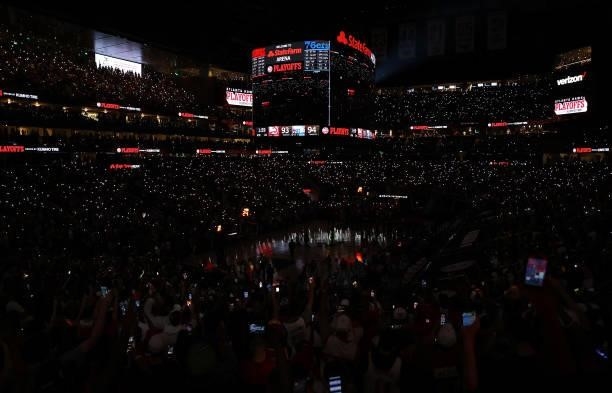 Fans use their cell phones to light the court after the lights went out as play resumed with just under two minutes left in the fourth quarter in...
