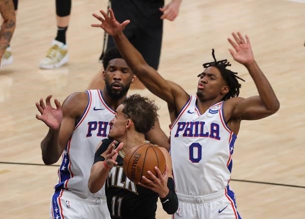 Trae Young of the Atlanta Hawks drives against Joel Embiid and Tyrese Maxey of the Philadelphia 76ers during the second half of game 6 of the Eastern...