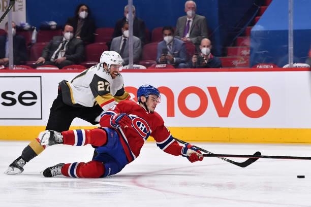Nick Suzuki of the Montreal Canadiens is checked by Shea Theodore of the Vegas Golden Knights during the first overtime period in Game Three of the...