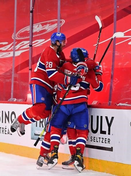 Josh Anderson of the Montreal Canadiens is congratulated by Paul Byron, Jon Merrill and Jesperi Kotkaniemi after scoring the game-winning goal...