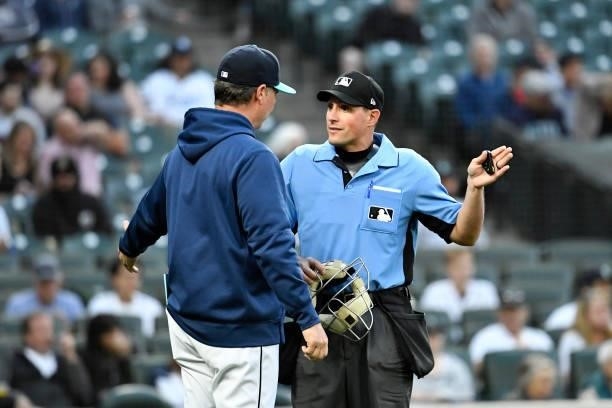 Scott Servais of the Seattle Mariners chats with umpire Quinn Wolcott during the game against the Tampa Bay Rays at T-Mobile Park on June 18, 2021 in...