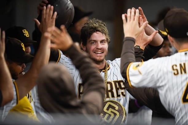 Wil Myers of the San Diego Padres is congratulatd in the dugout after hitting a solo homer run during the second inning of a baseball game against...