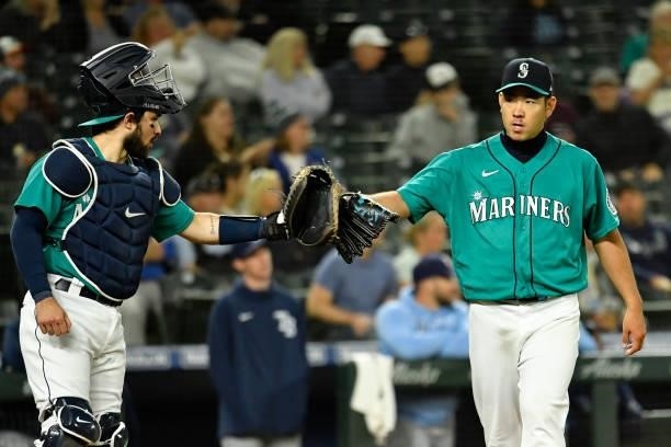 Yusei Kikuchi of the Seattle Mariners and Luis Torrens bump gloves during the game against the Tampa Bay Rays at T-Mobile Park on June 18, 2021 in...